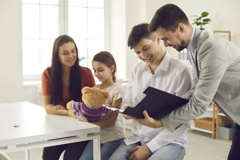 Happy couple with child meeting with bank manager, financial adviser or real estate agent