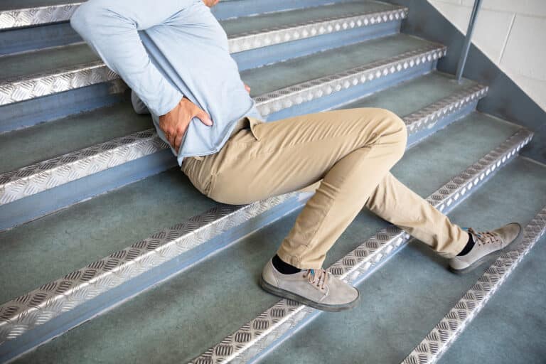 Mature Man Lying On Staircase After Slip And Fall Accident