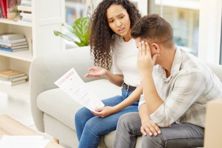 Shot of a young couple looking stressed while holding an eviction notice.