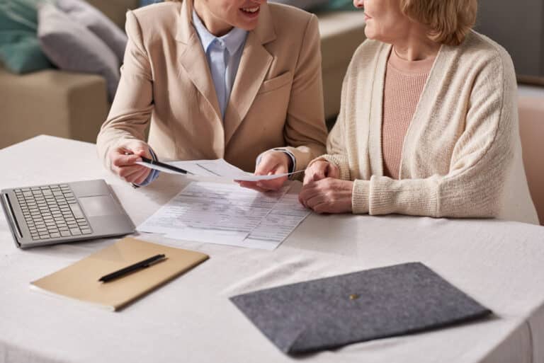 Close-up of businesswoman giving a consultation to senior woman about financial documents during their business meeting