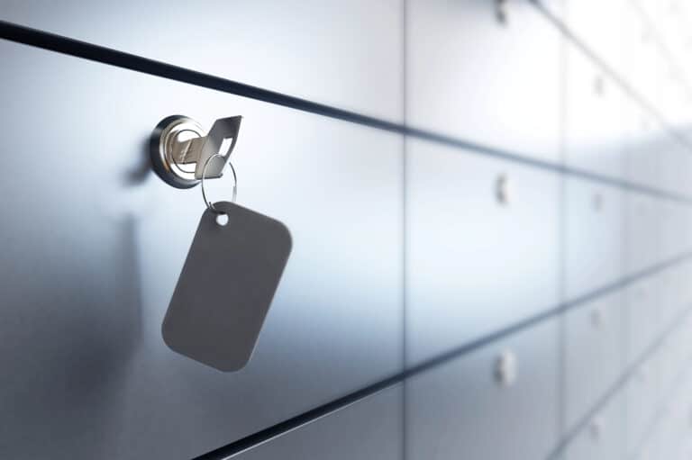 A key is gently inserted into the lock of a metal safe deposit box, often containing vital documents needed for navigating the intricacies of Florida Probate.